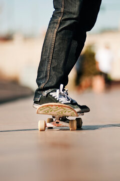 Low section of man standing on skateboard at park