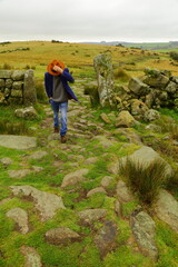 Man with hat walks in Dartmoor National Park, Devon UK