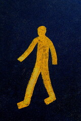 Yellow  pedestrian walking sign on the asphalt