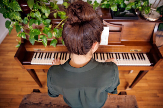 High angle view of woman playing piano at home