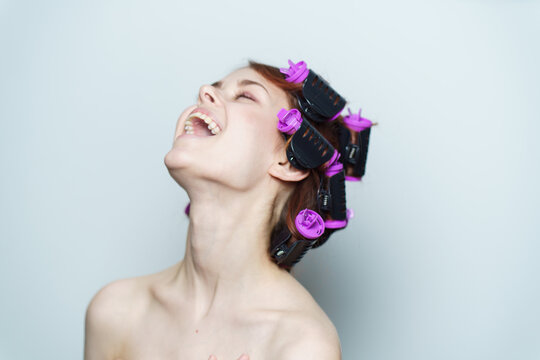 pretty woman with curlers on her head hairstyle naked shoulders makeup