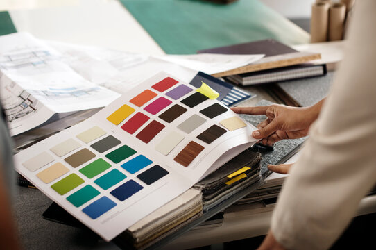 Cropped image of interior designer examining color swatches at office