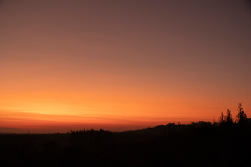 Fototapeta na wymiar Morning blur over mountains and trees. The first and last light of the day in sky with beautiful
