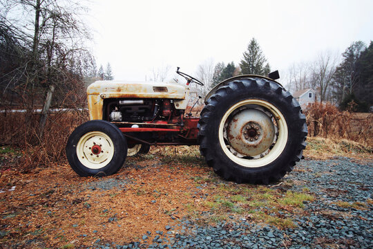 Fototapeta Old tractor parked on field against sky