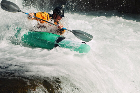 Whitewater kayaker descending waterfall rapids