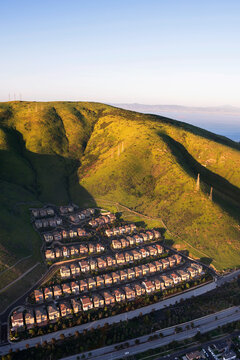Aerial view of row houses on green landscape against clear sky