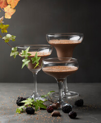 Close up of three glasses with chocolate mousse dessert on dark background with copy space. . High quality photo