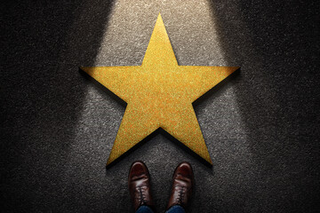 Success in Business or Personal Talent Concept. Top View of Business Person in Working Shoes Standing in front of a Golden Star. Light Shining on the Dark Cement Floor - obrazy, fototapety, plakaty