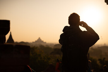 a man watching sunrising from pagoda