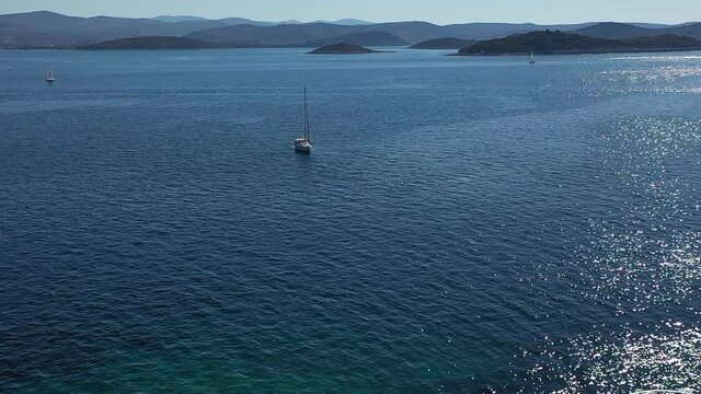Aerial View of Lighthouse Tower on Small Island and Sailing Boat in Blue Sea on Sunny Day With Croatian Coastline in Background, 50fps Drone Shot