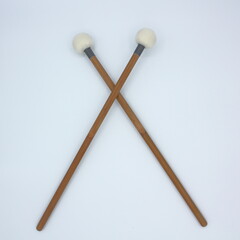  Crossed timpani mallets on a white background.