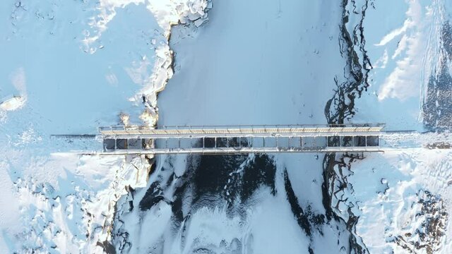 Aerial of bridge between continents in Iceland covered in white snow
