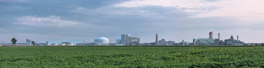 Fototapeta na wymiar Fertilizer plant in an agricultural landscape. Corn and soybeans share acreage with a new manufacturing facility.