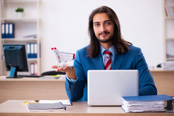 Young male employee in ecommerce concept in the office