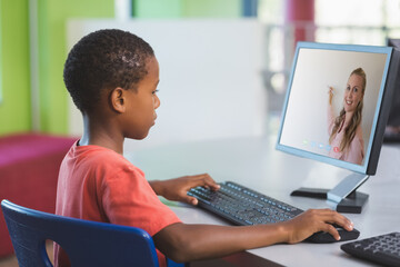 Male african american student having a video call with female teacher on computer at school
