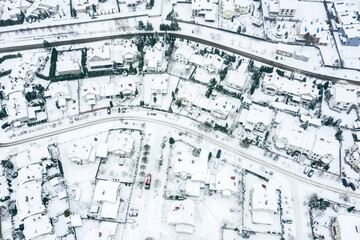 snow-covered houses, roads and courtyards at winter season. suburban neighborhood after a snowstorm. aerial photo