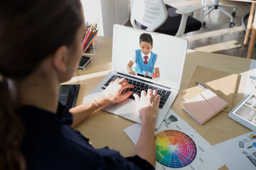 Obraz na płótnie Canvas Female teacher having a video call with male student on laptop at school