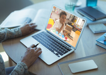 Mid section of female teacher having a video call with male student on laptop at school