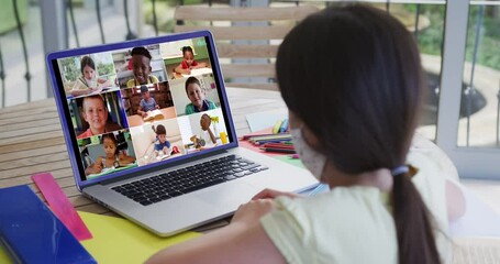 Caucasian schoolgirl in face mask using laptop on video call with school friends - Powered by Adobe