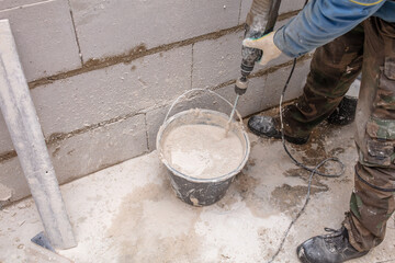 A worker kneads the mixture into plaster buckets. Home renovation