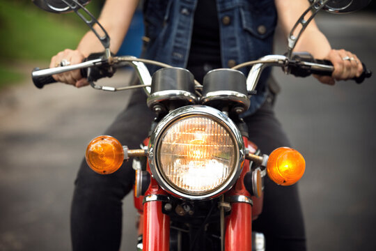 Midsection of woman riding motorcycle on road