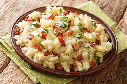 Potatoes, Bacon and Sauerkraut is Strapacky halusky closeup in the plate on the table. horizontal