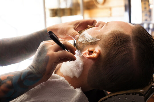 Cropped image of barber shaving customer