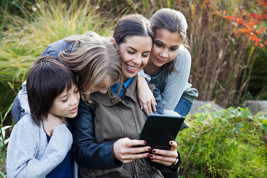 Teacher showing tablet computer to children during field trip