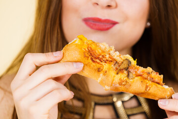 Woman eating hot pizza slice