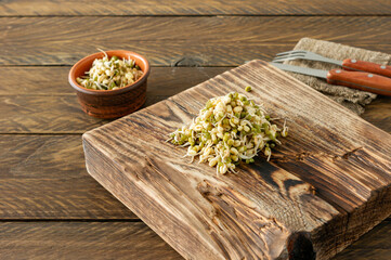 Macrobiotic food. Sprouted mung beans ready to eat on wooden serving board. Rustic style