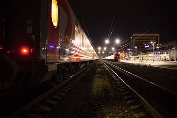 Fototapeta na wymiar Railway cars stand on the tracks. Night, lanterns are on.