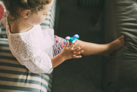 High angle view of girl playing with fidget spinner in living room at home