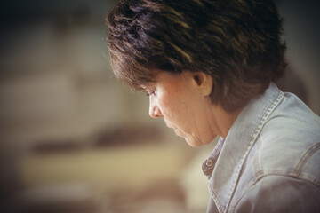 Side view of serious craftswoman working at workshop