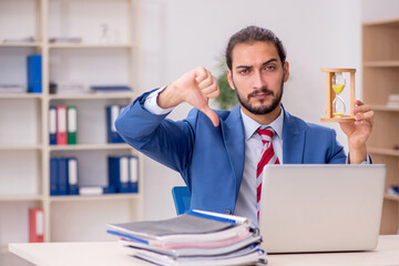 Young male employee in time management concept