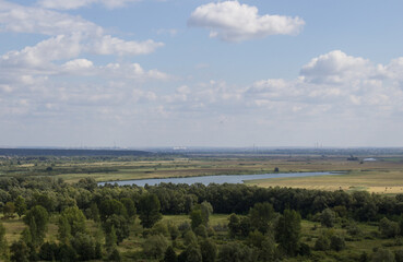 Beautiful natural background: sky, trees, river, field