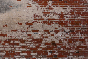 old brick wall with layers of old plaster and paint, background