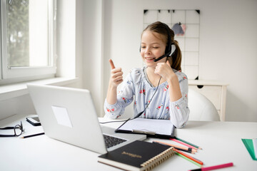 Smiling little girl study online using laptop