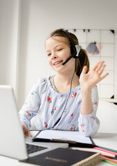 Smiling little girl study online using laptop