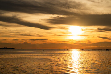 View of sunset at the sea with cockle farm.