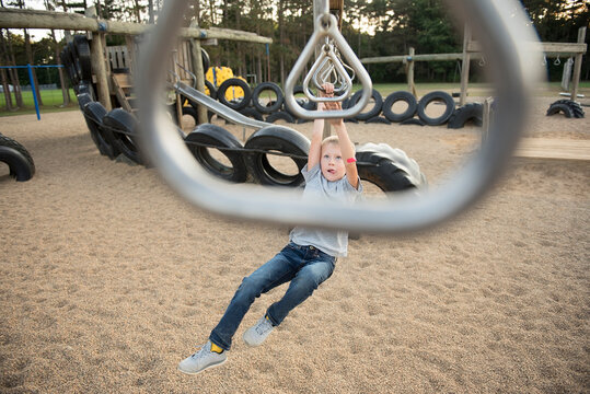 High angle view of boy hanging on monkey bars at playground