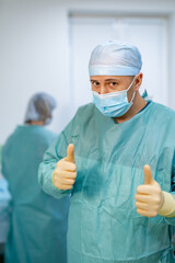 Fototapeta na wymiar Portrait of male surgeon wearing surgical mask in operation theater at hospital