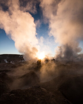 Silhouette people standing at volcanic landscape against sky during sunset