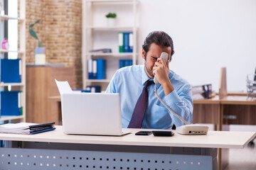 Obraz premium Young male employee working in the office