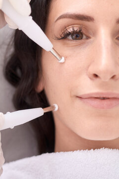 Portrait of confident patient having beauty treatment by female doctor at medical clinic