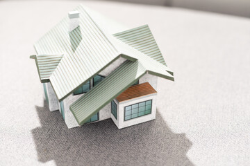 Volumetric project of house. Layout of a house with an open roof. Miniature layout of a cottage top view. Building model as a symbol of architectural business. Design in architectural bureau.