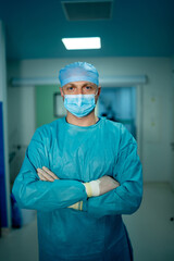Fototapeta na wymiar Portrait of male surgeon wearing surgical mask in operation theater at hospital.