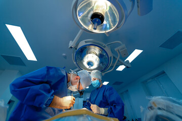 In surgery. Medical team performing operation in hospital operating theater. Working with surgical...