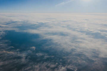 Fototapeta na wymiar 飛行機の窓から見る雲と空
