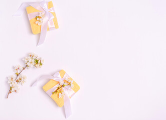 Gift boxes with branches of blossoming cherry on a white background.