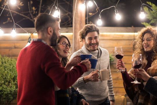 Happy Friends Enjoying Drinks In Dinner Party At Backyard